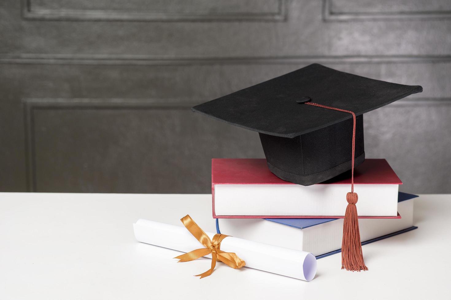 Graduation cap with books on white desk , Education background photo