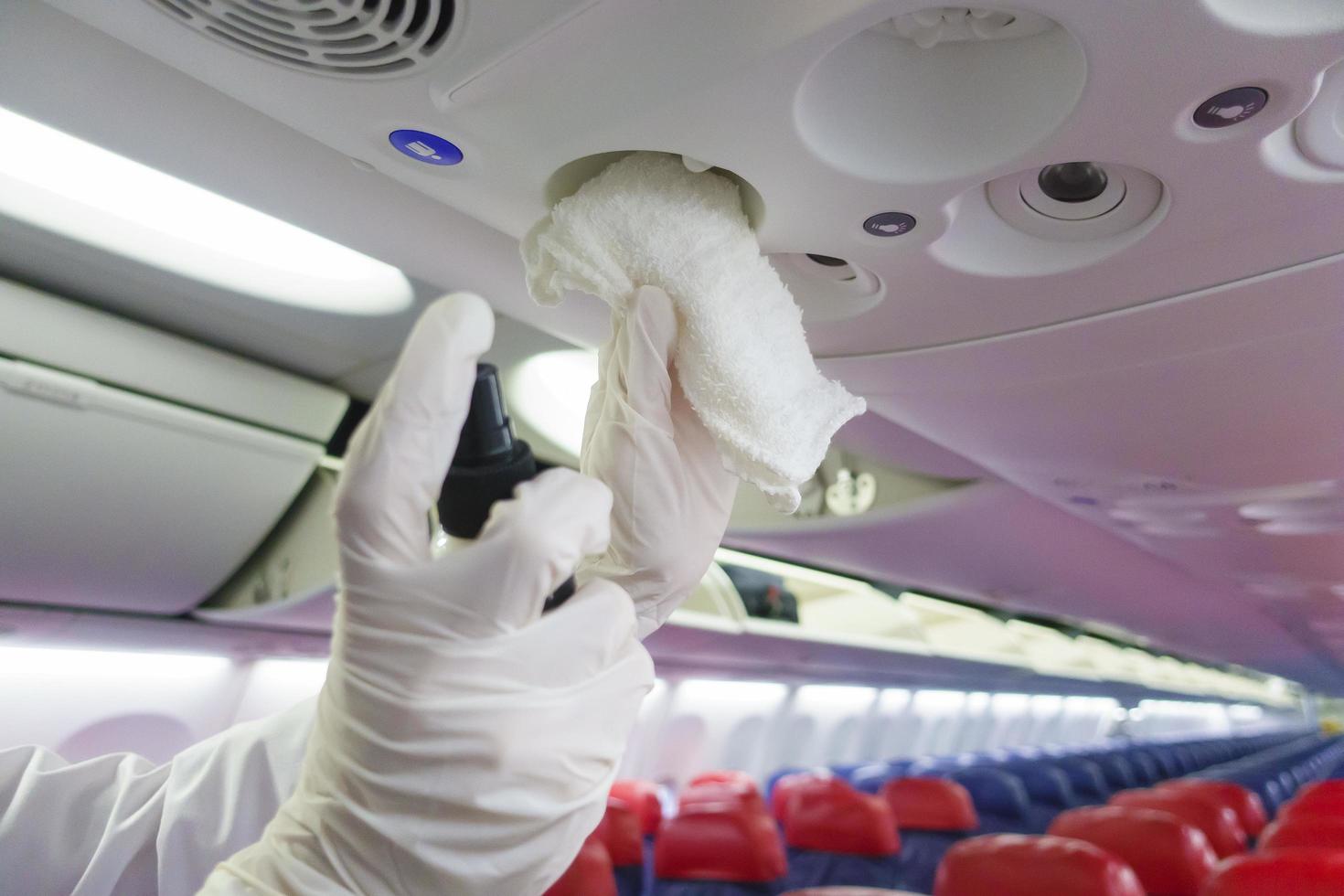 Close up hand is wearing gloves cleaning aircraft for covid-19 prevention pandemic photo