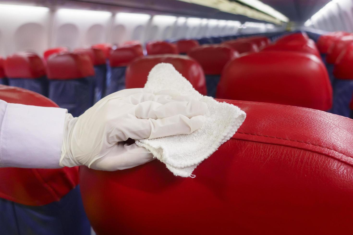 Close up hand is wearing gloves cleaning aircraft seat for covid-19 prevention pandemic photo