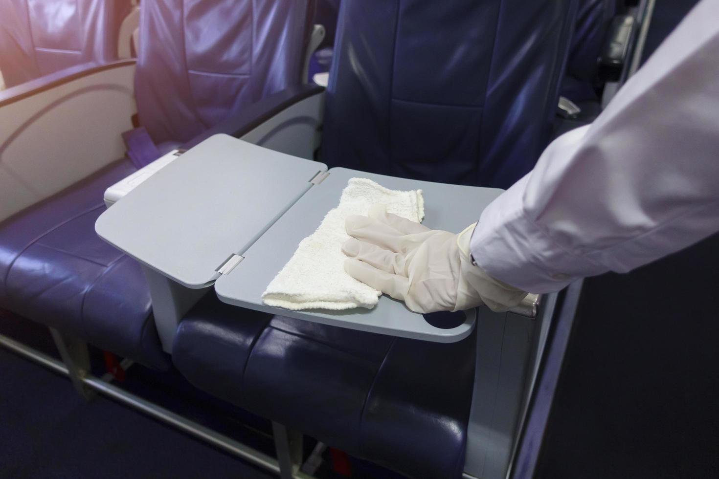 Close up hand is wearing gloves cleaning aircraft seat for covid-19 prevention pandemic photo