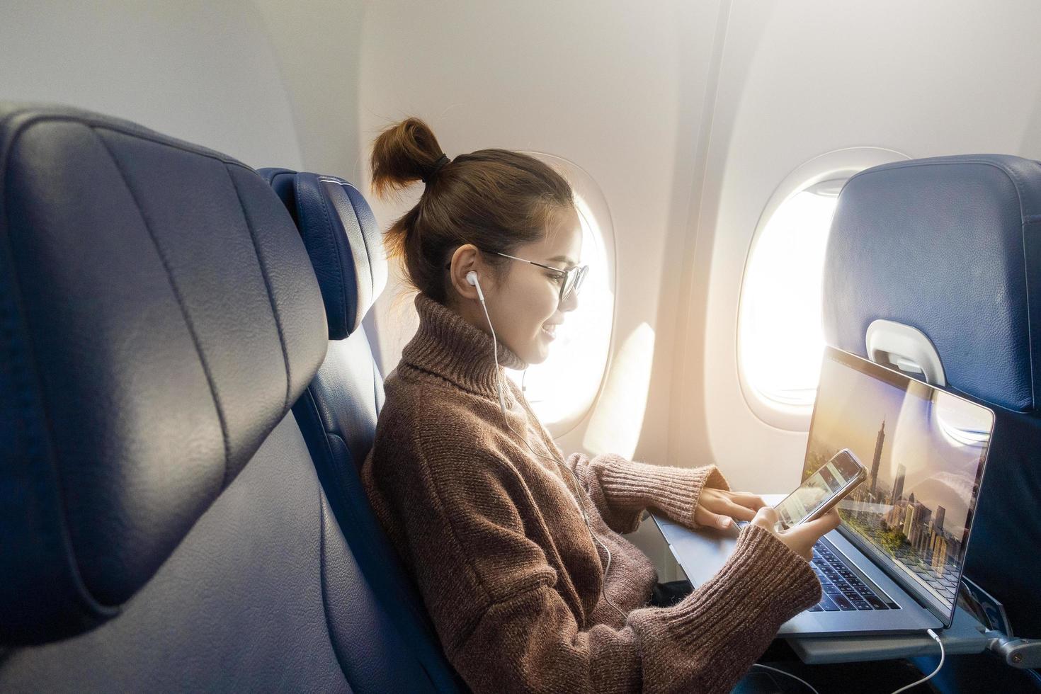 una mujer joven con mascarilla viaja en avión, nuevo viaje normal después del concepto de pandemia covid-19 foto