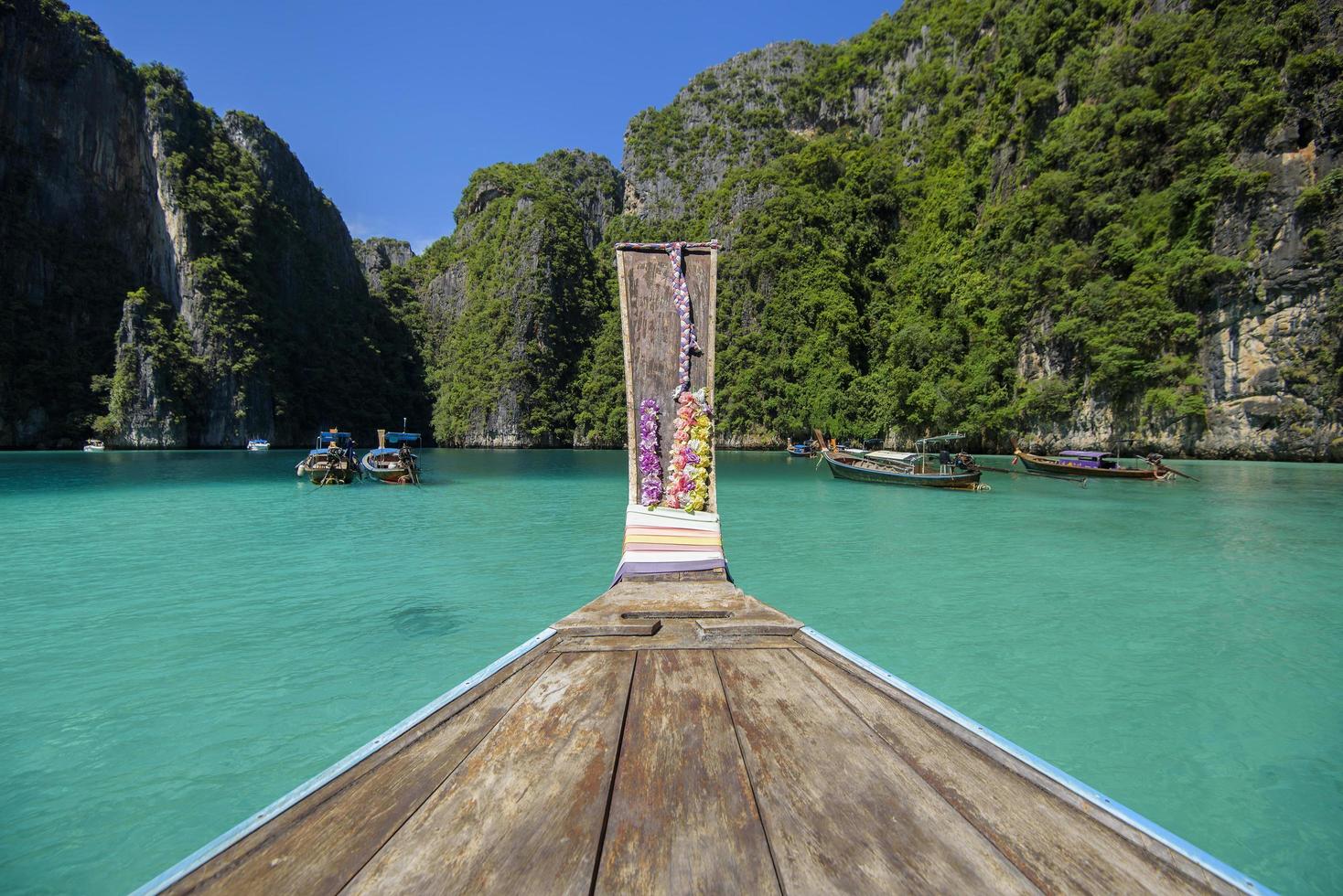 vista del barco de cola larga tradicional tailandés sobre el mar claro y el cielo en el día soleado, islas phi phi, tailandia foto