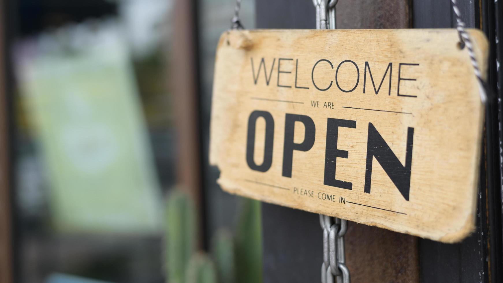 Open sign in coffee shop door , business reopen After Covid-19 outbreak concept . photo