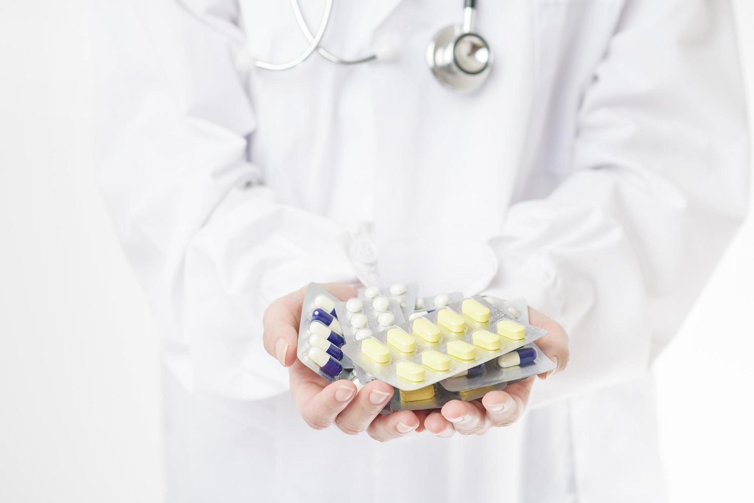 Close up doctor hand is holding pills on white background photo