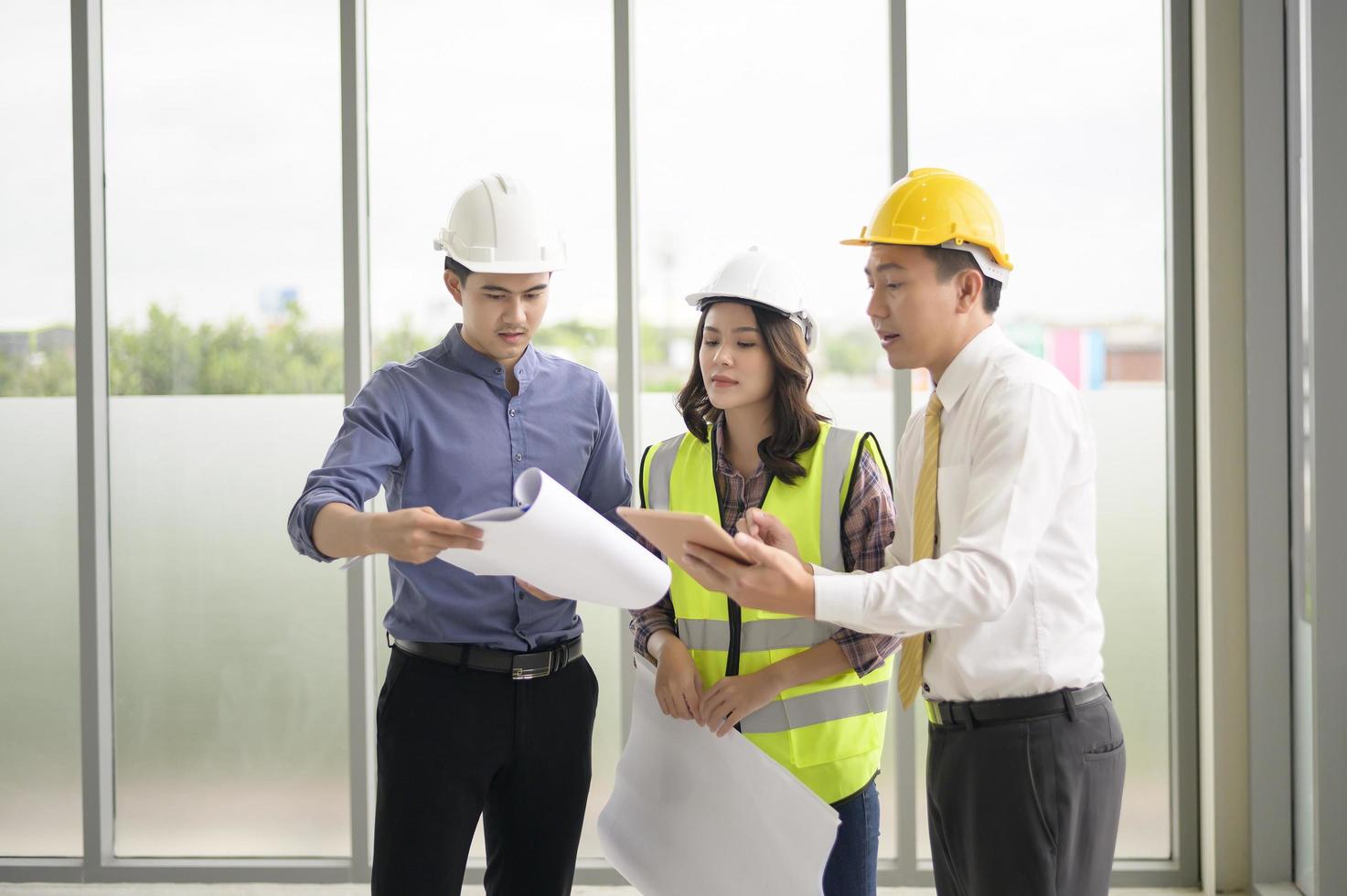 los ingenieros son planes de construcción analíticos con planos en la oficina foto