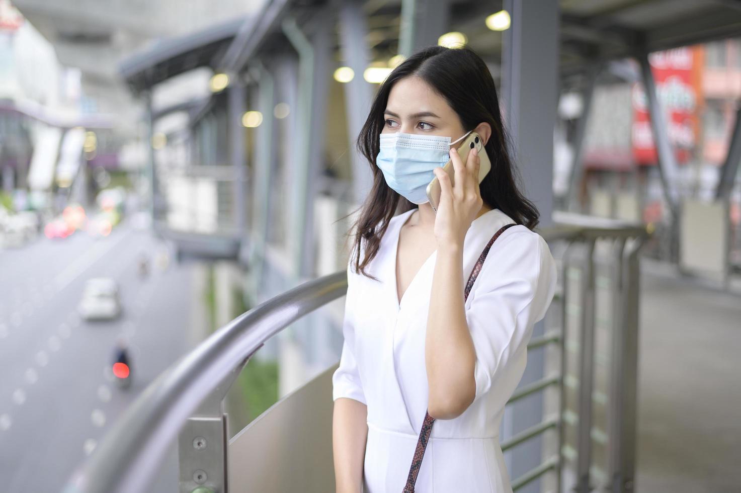 una mujer joven lleva mascarilla en la calle de la ciudad. foto