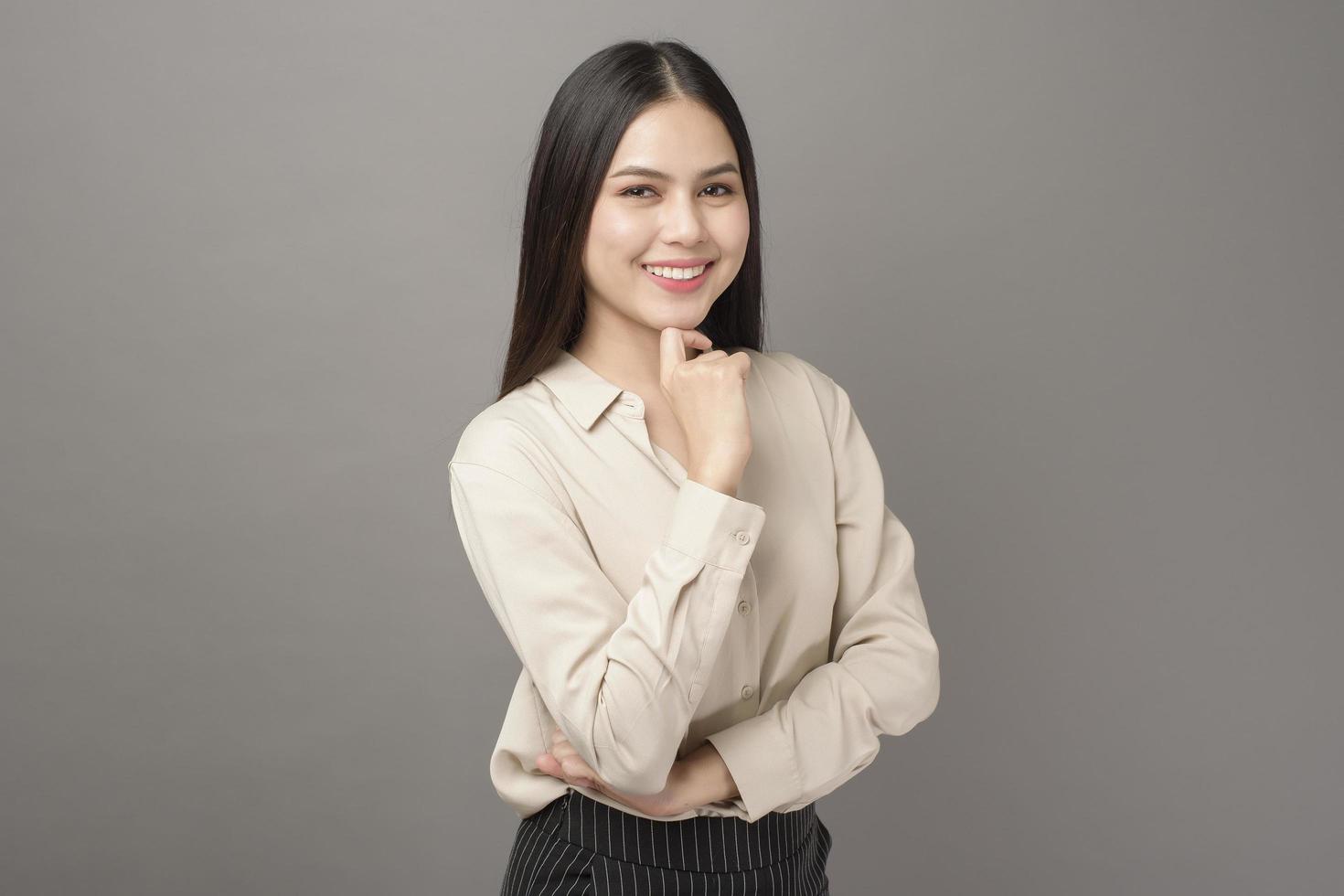 Portrait of beautiful business woman smiling on gray background photo