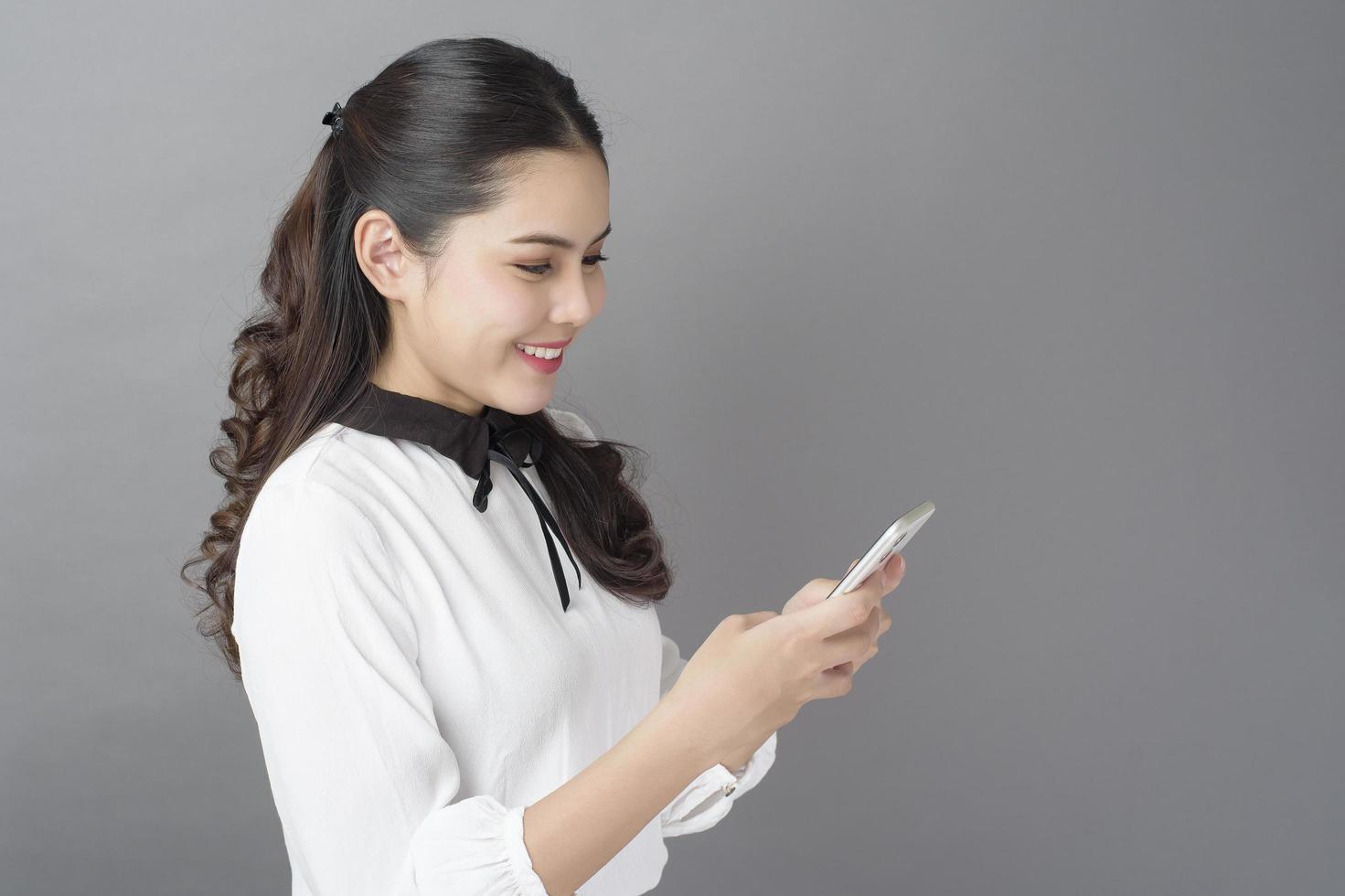 retrato de una hermosa mujer de negocios está usando un celular en el estudio foto