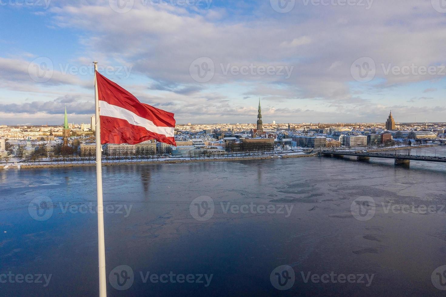 vista panorámica de la ciudad de riga con una gran bandera letona junto al río daugava. espíritu letón. foto