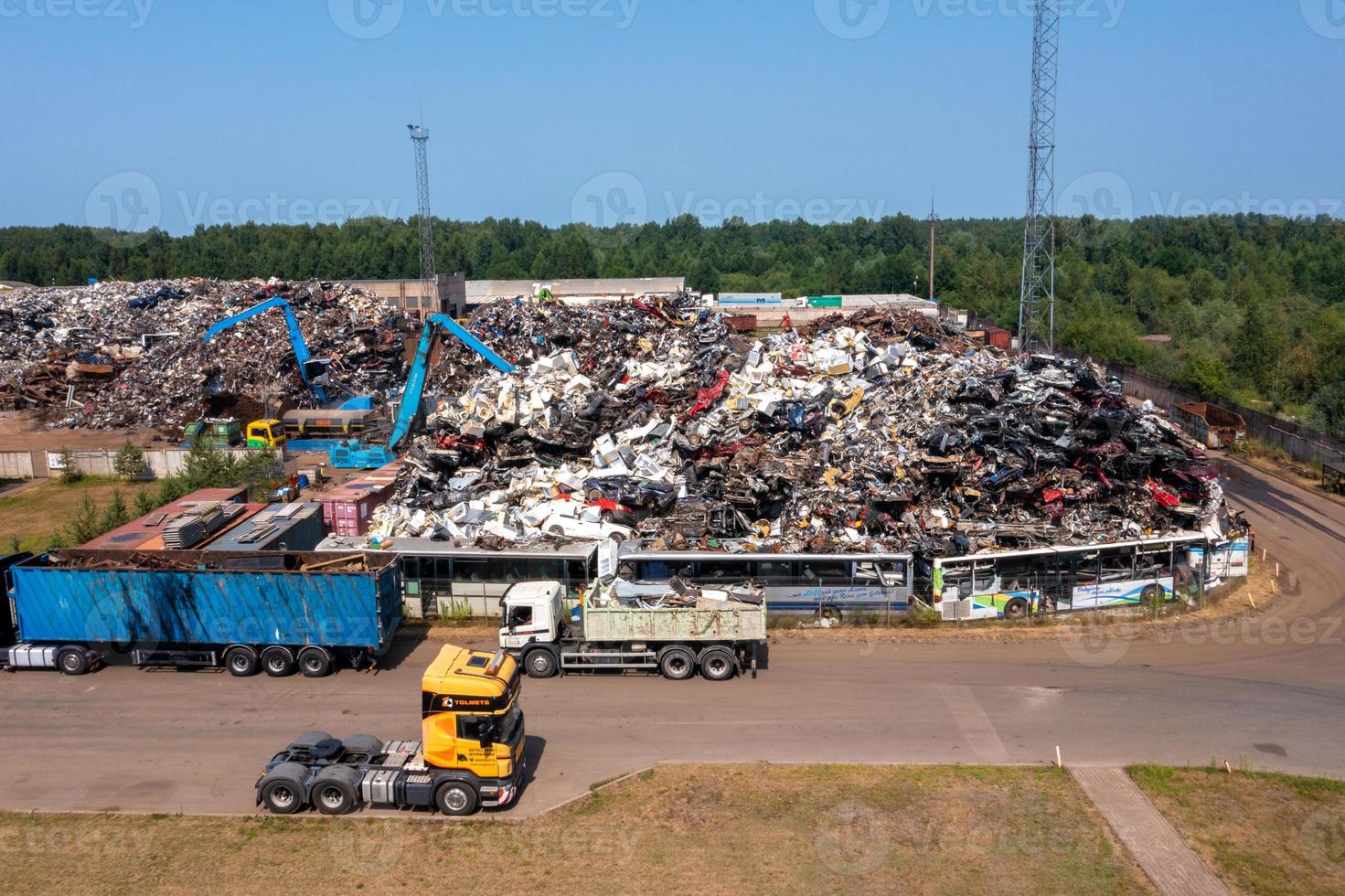 Old damaged cars on the junkyard waiting for recycling photo