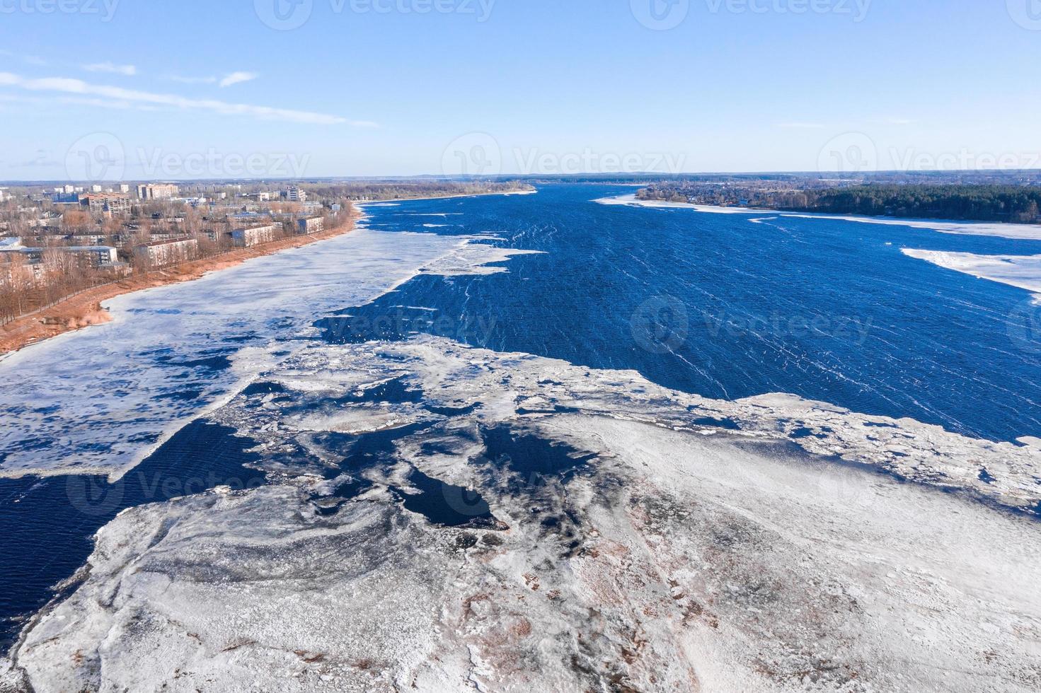 vista aérea del puente sur sobre el río daugava en letonia con patrones de hielo flotando en el río. foto