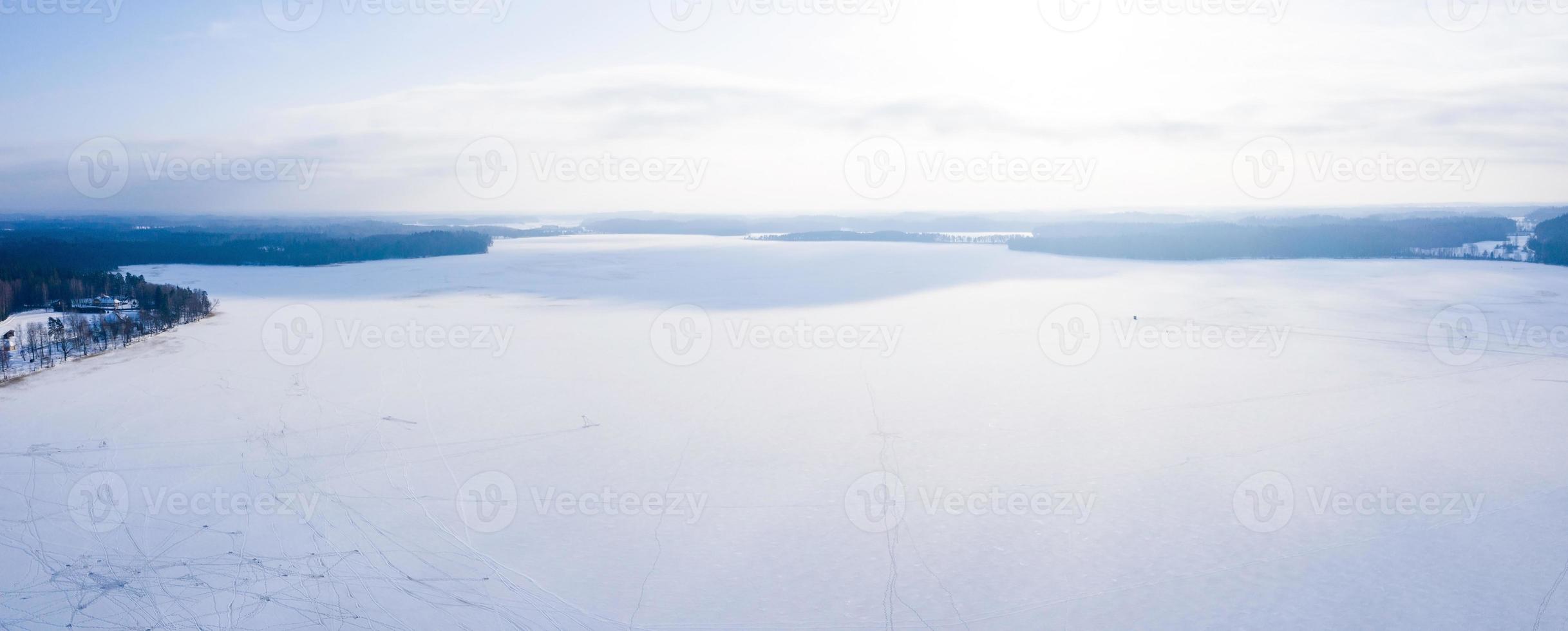 Beautiful aerial view of the huge frozen lake in the middle of a forest in Latvia. Frozen Ungurs lake in Latvia. photo