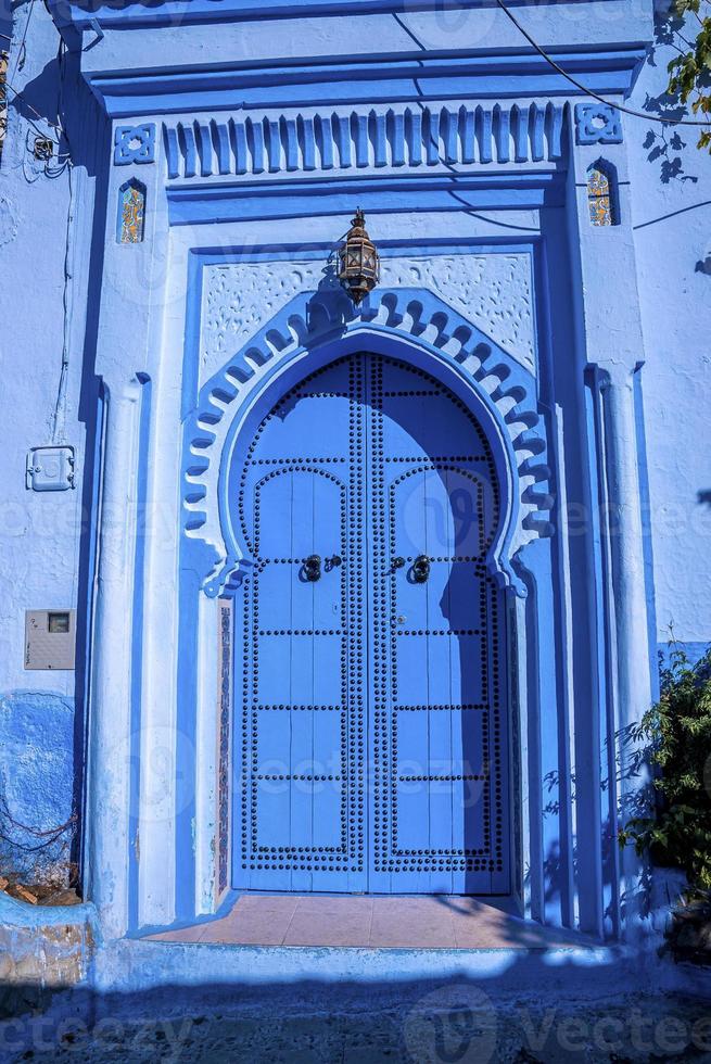 puerta cerrada de casa con entrada arqueada en la ciudad azul de chefchaouen foto
