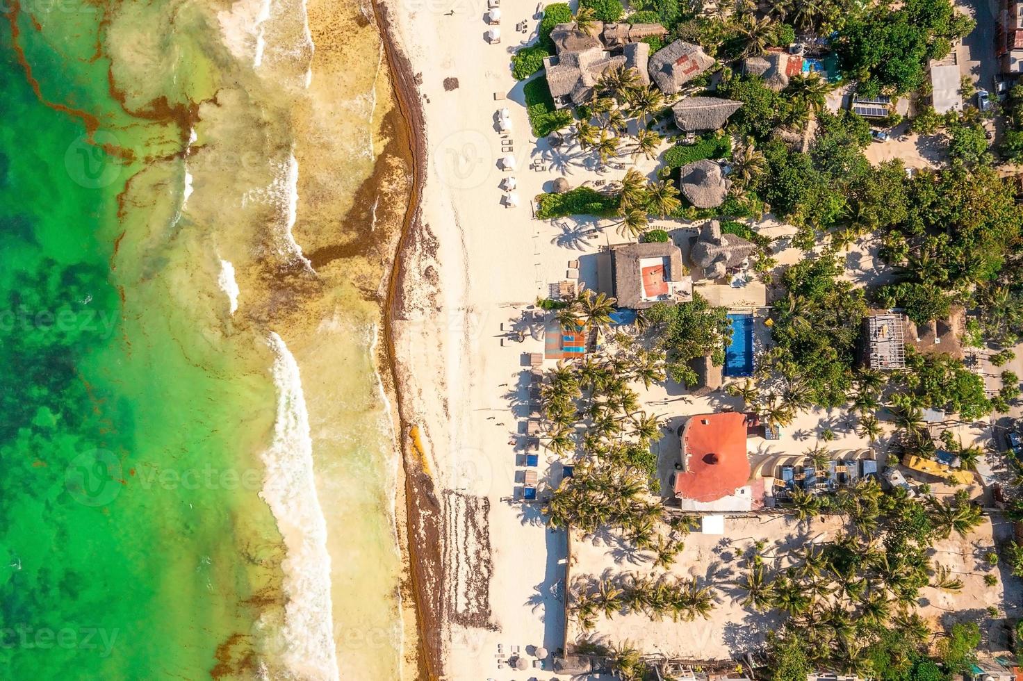 Aerial Tulum coastline by the beach with a magical Caribbean sea and small huts by the coast. photo