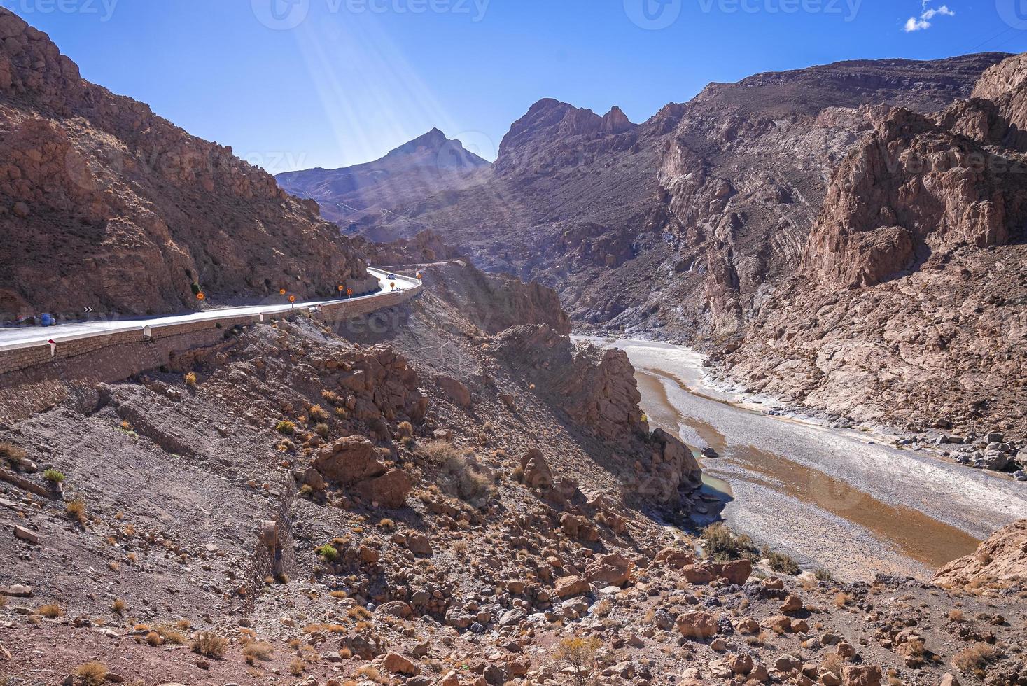 hermoso camino sinuoso a través de montañas con río en verano foto
