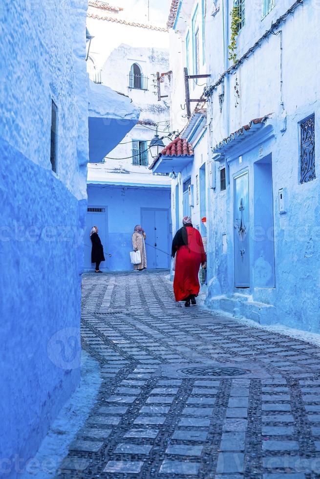 mujeres caminando por un callejón estrecho entre casas tradicionales foto