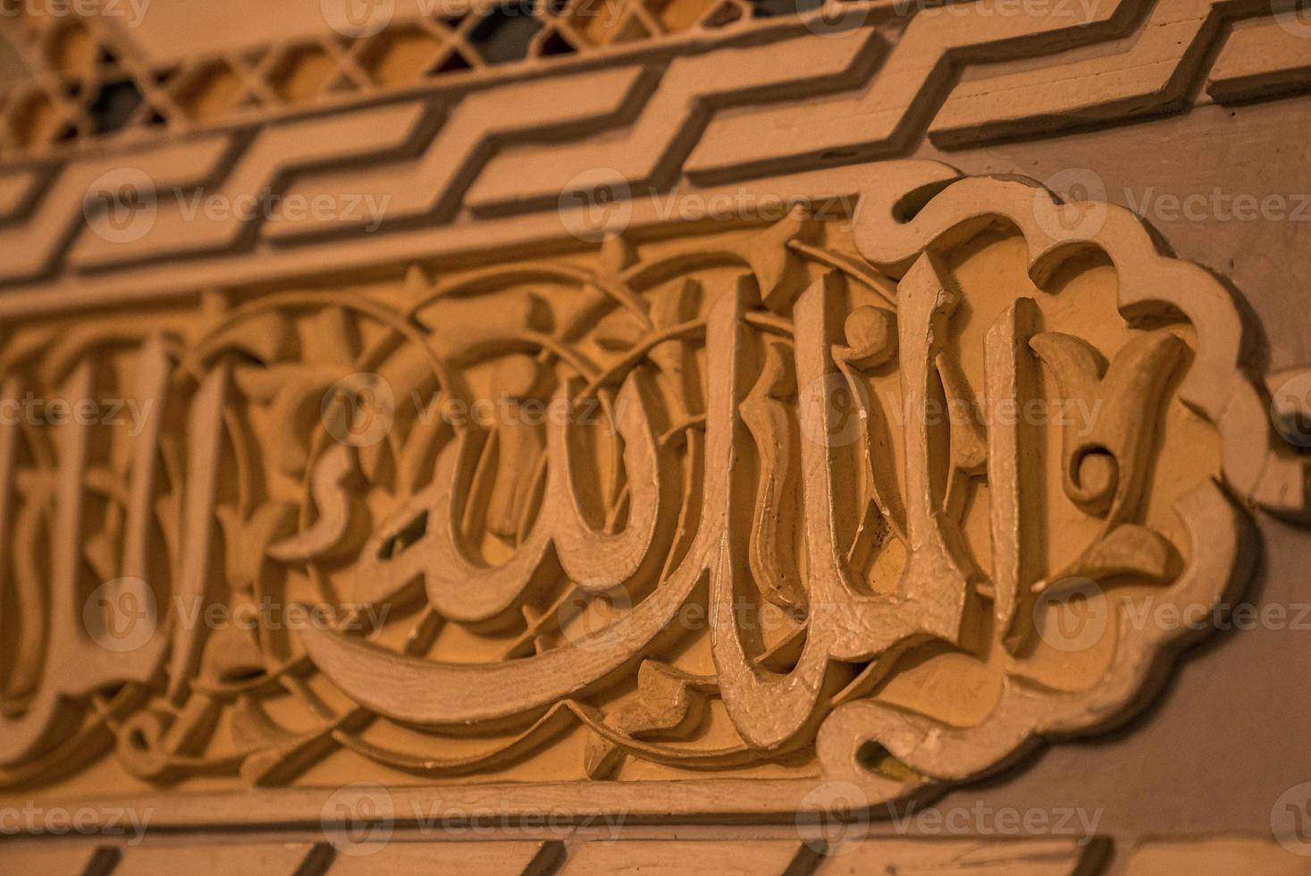 Close up of arabic script carved on wood photo