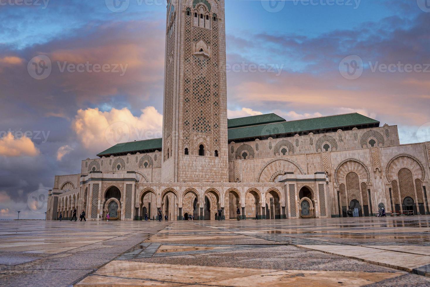 View of Hasan ii mosque with wet square in foreground during dusk photo