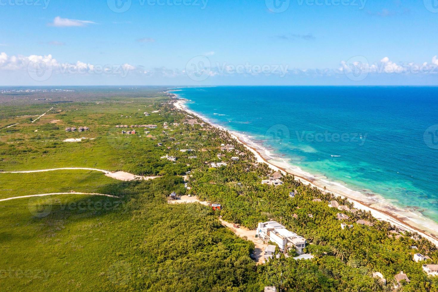 Aerial Tulum coastline by the beach with a magical Caribbean sea and small huts by the coast. photo