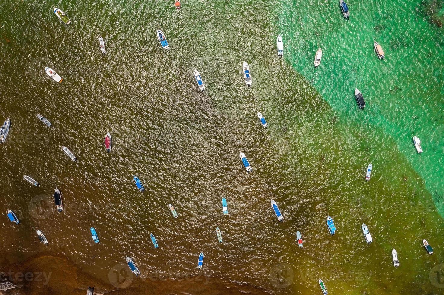 Aerial view of many sailing boats anchoring next to reef. photo