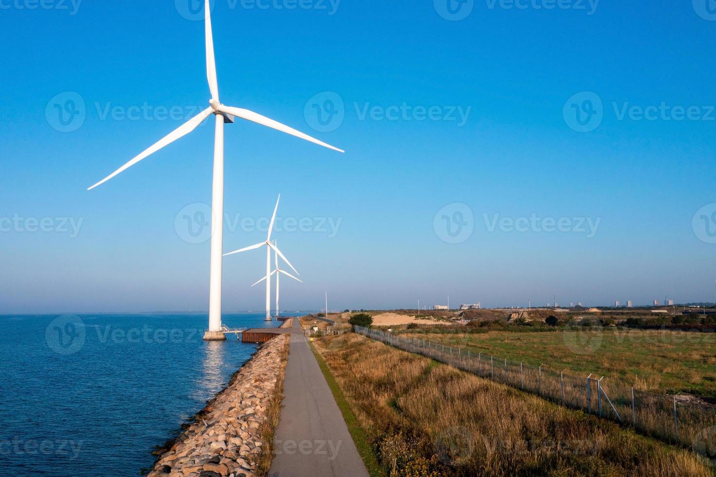 Aerial view of the wind turbines. Green ecological power energy generation. Wind farm eco field. Offshore and onshore windmill farm green energy at sea photo