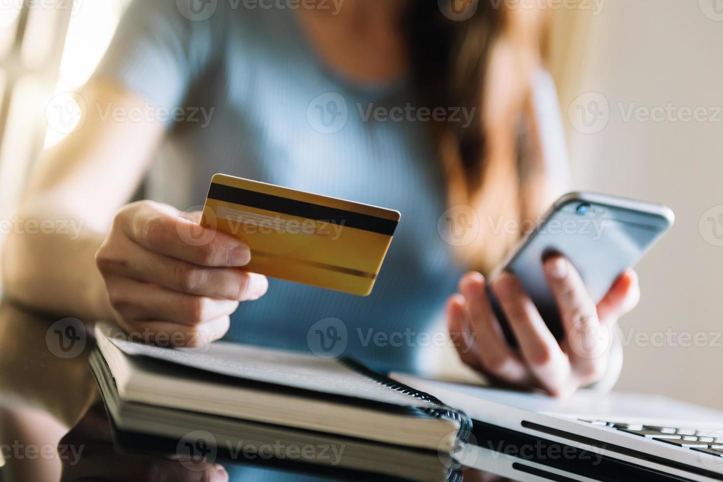 mujer que usa un teléfono inteligente para pagos móviles, compras en línea, canal omni, sentada en la mesa, pantalla de interfaz gráfica de iconos virtuales a la luz de la mañana foto