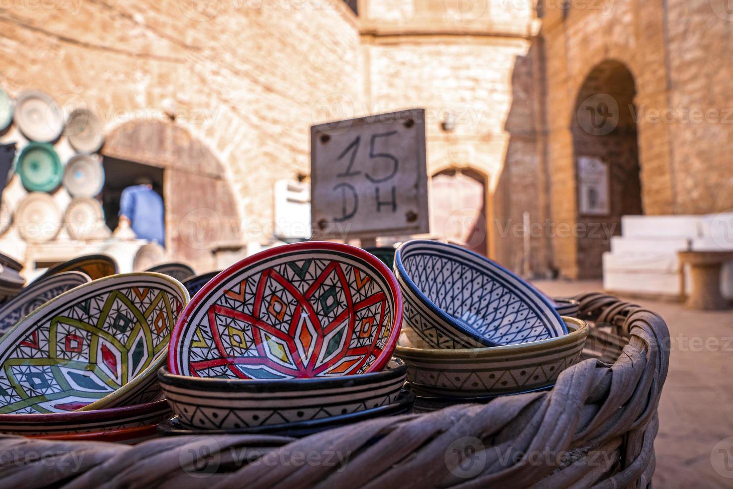 Handmade colorful decorated bowls on display for sale in market photo