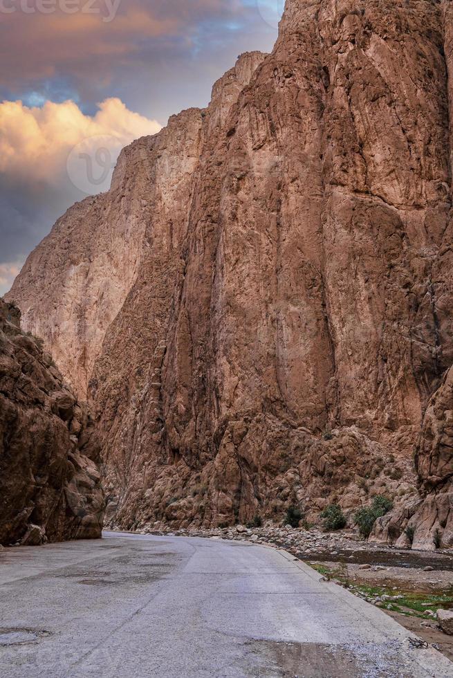 vista panorámica de la carretera vacía a lo largo del río a través de las montañas rocosas foto