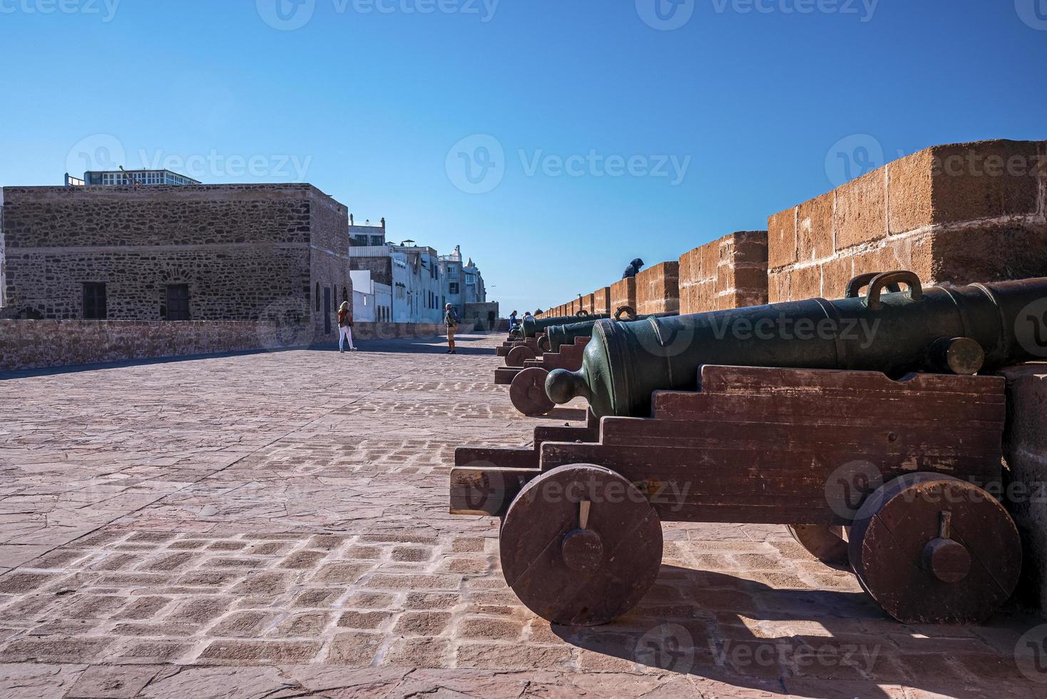 Old cannon aimed through slit in stone wall at historic fortress photo