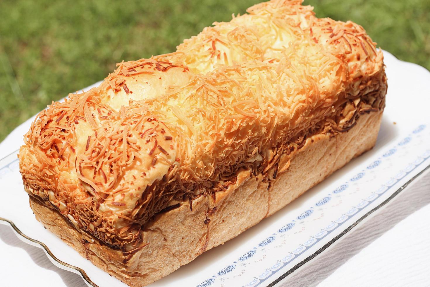 Freshly baked multi-grain bread with homespun fabric on white background. Low key still life with directional natural lighting. photo