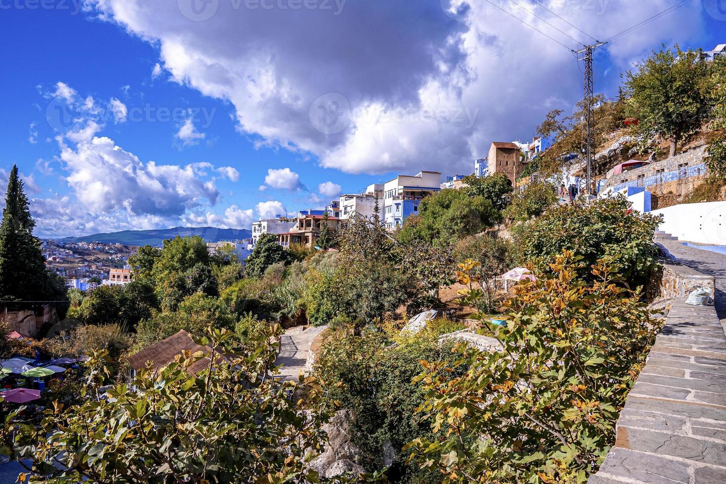 Aerial view of residential structures and mountain against cloudy sky photo