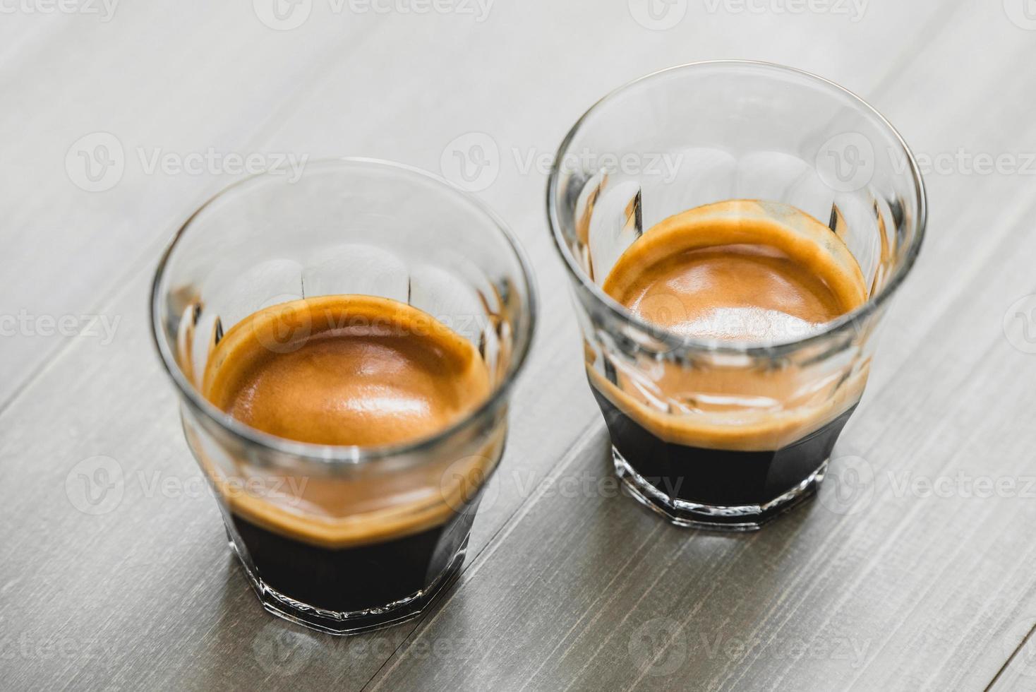 Double shot Espresso coffee in the glasses on vintage wood table background photo