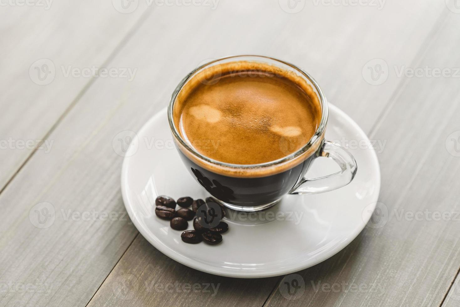 Fresh hot cup of brewed espresso coffee served on a saucer in vintage wooden table photo