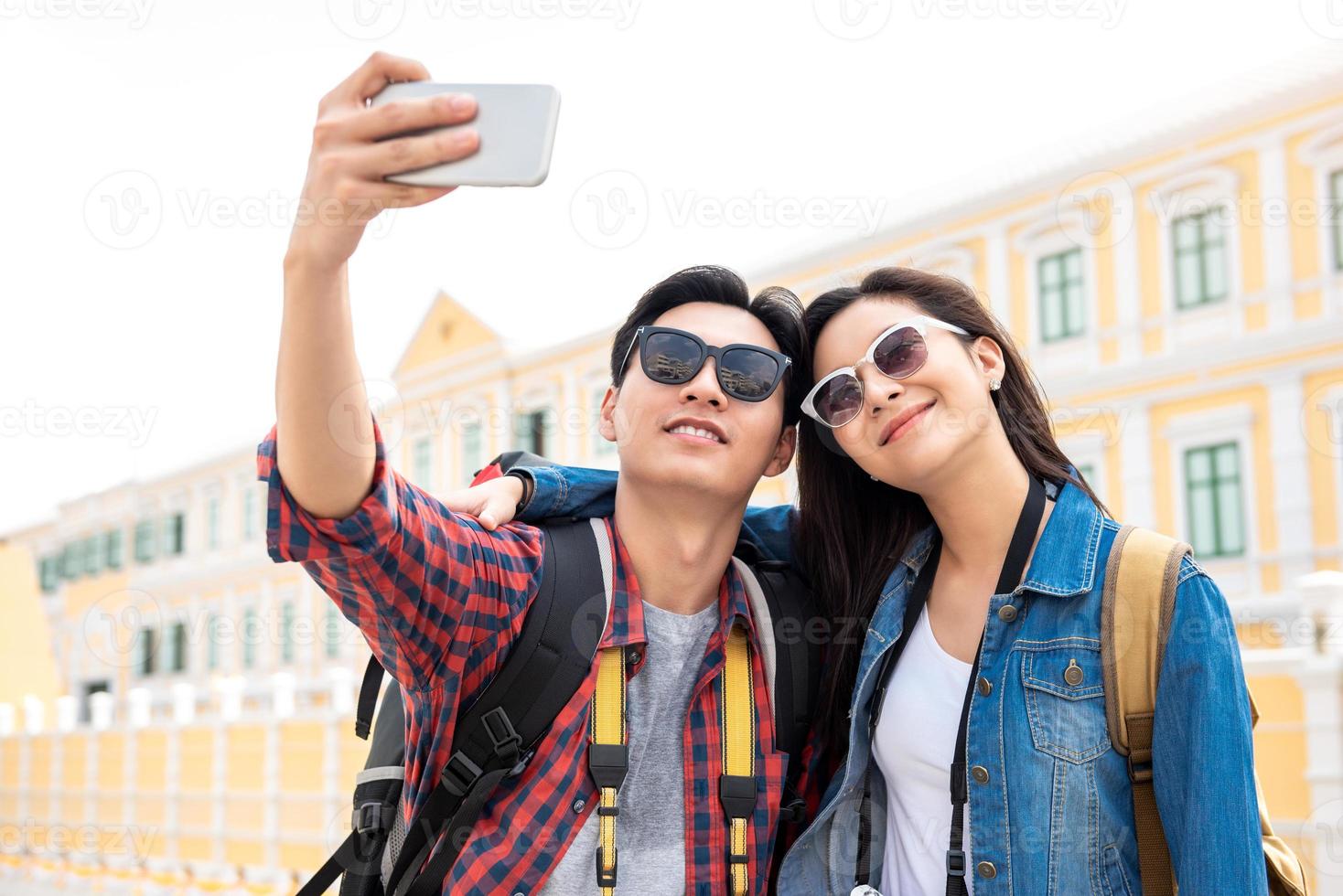 joven pareja de turistas asiáticos tomando un selfie en bangkok, tailandia foto