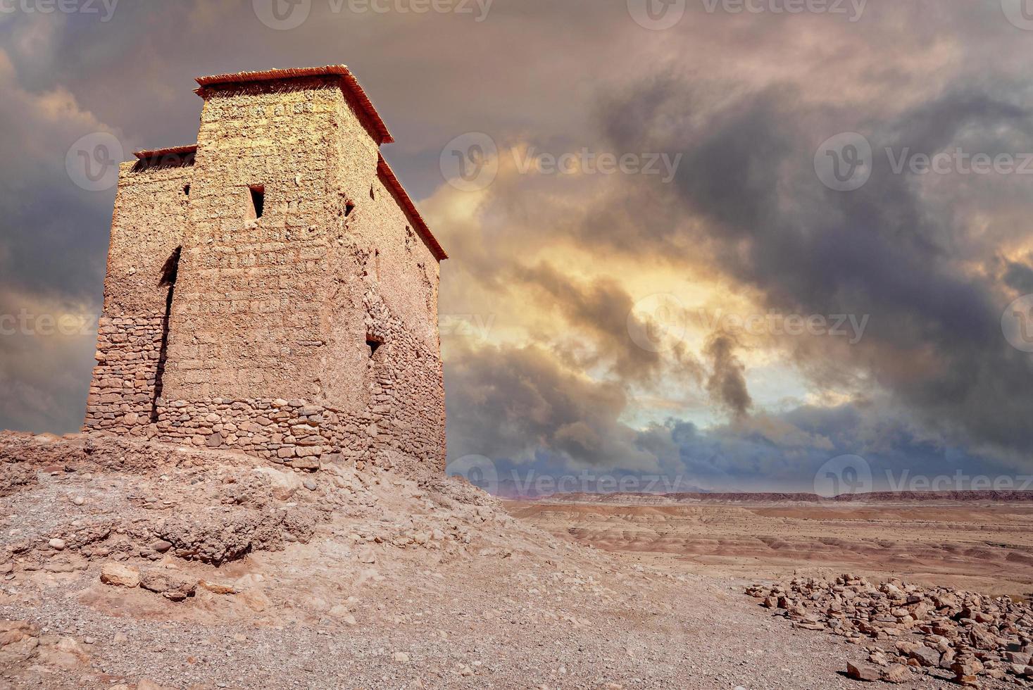 Earthen building surrounded by high walls on deserted land photo