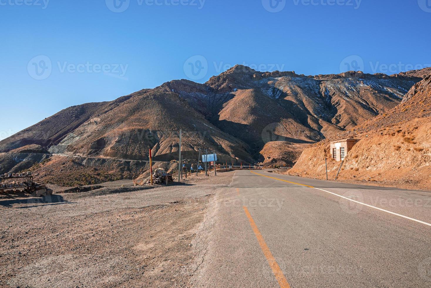 Carretera con curvas de asfalto vacío a través de las montañas en un día soleado de verano foto