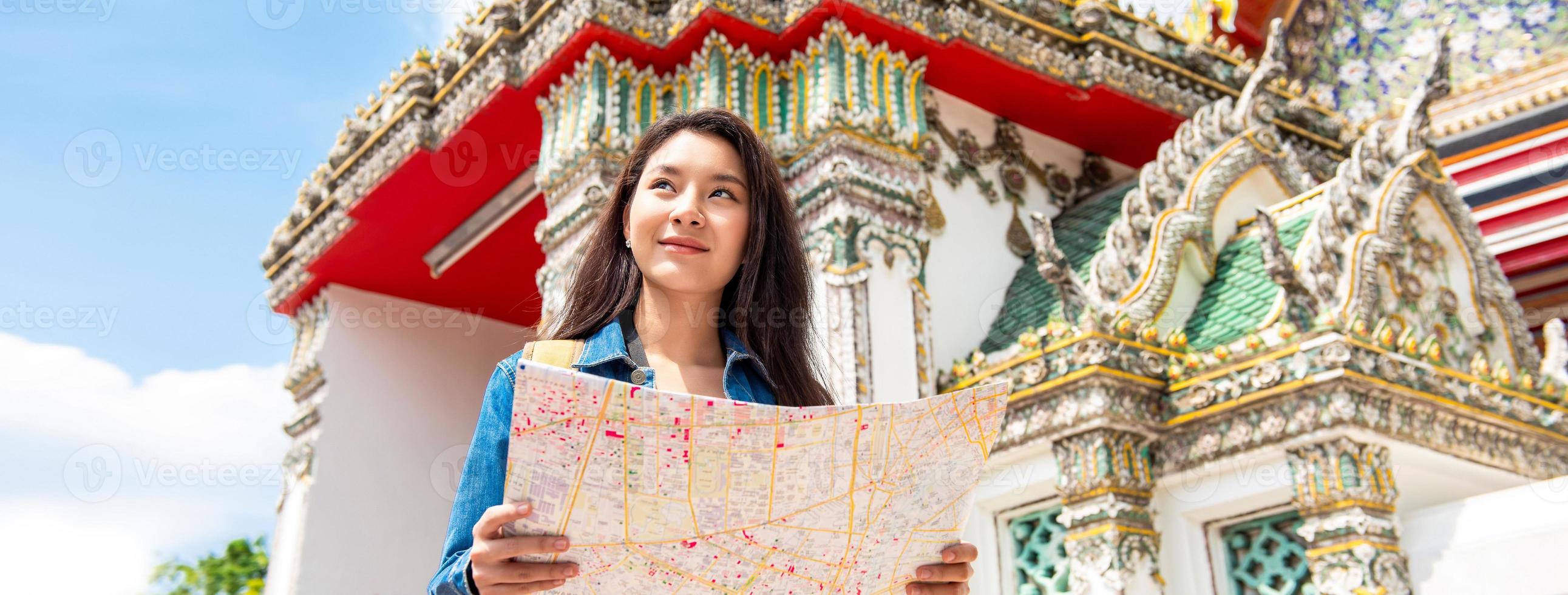 Banner picture of young Asian tourist woman backpacker solo traveling in ancient Thai temple during summer vacations in Bangkok Thailand photo