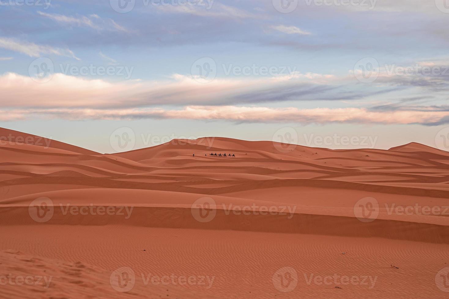 Impresionante vista de las dunas de arena con patrón de ondas en el desierto contra el cielo nublado foto