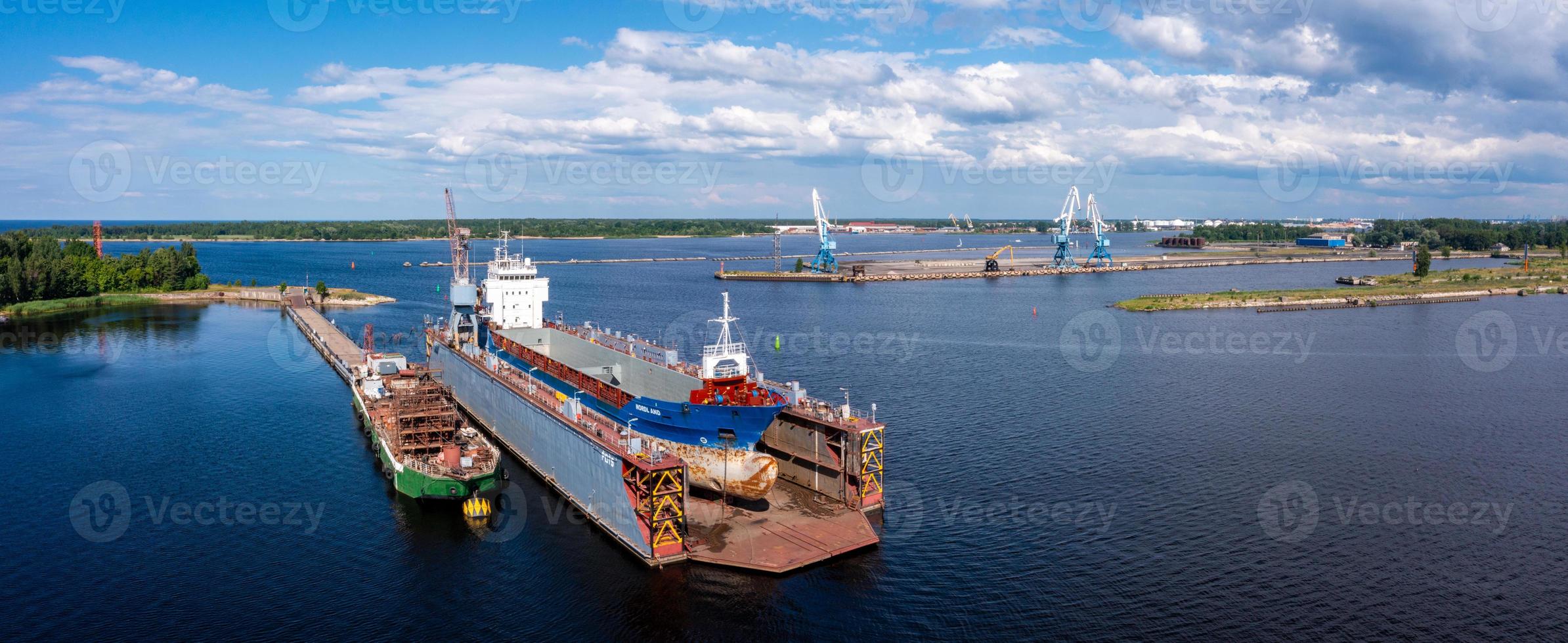 Riga, Latvia. June 10, 2021. Cargo ship at floating dry dock is being renovated photo