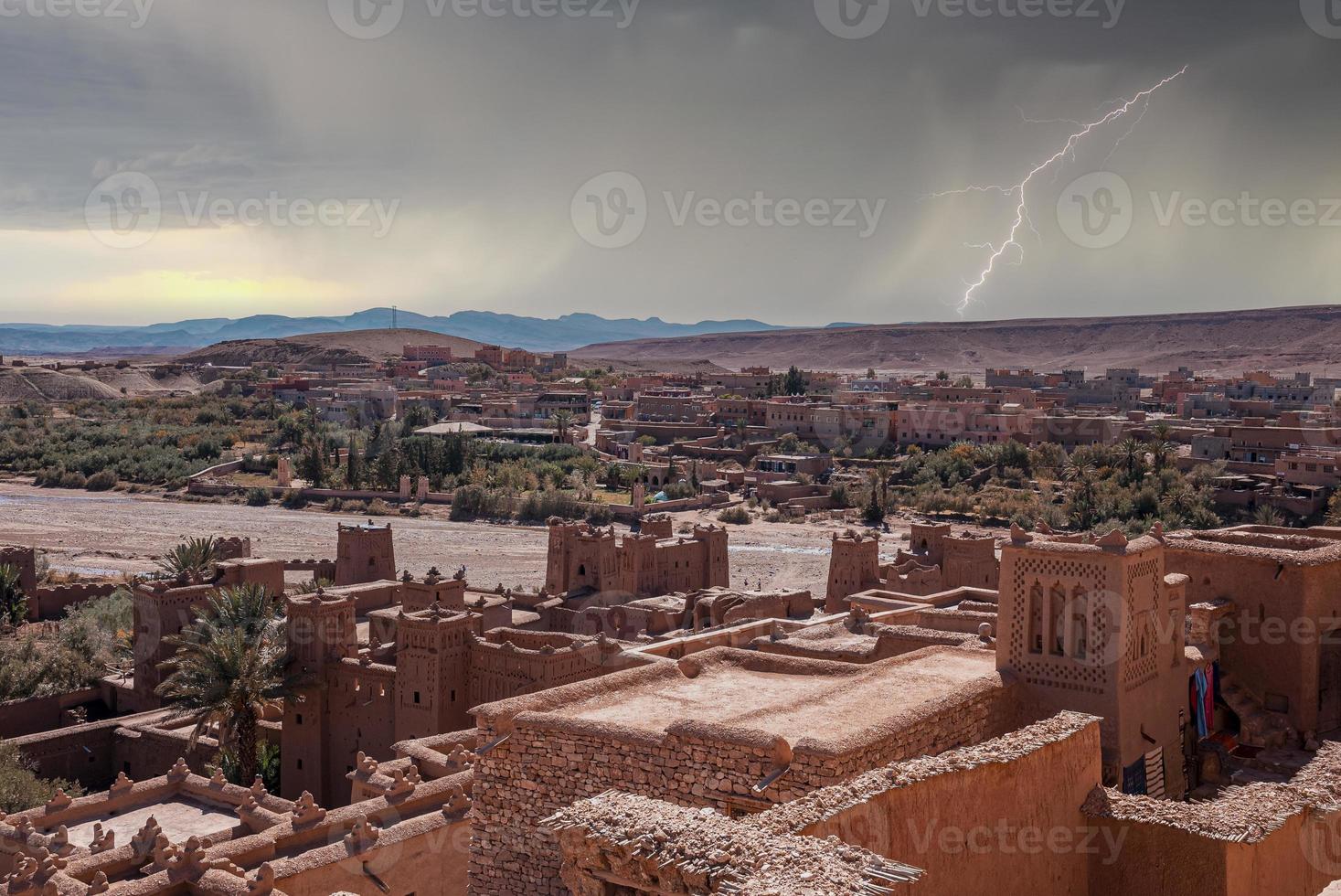 Ancient fortress and residential structures with thunderstorm in sky photo