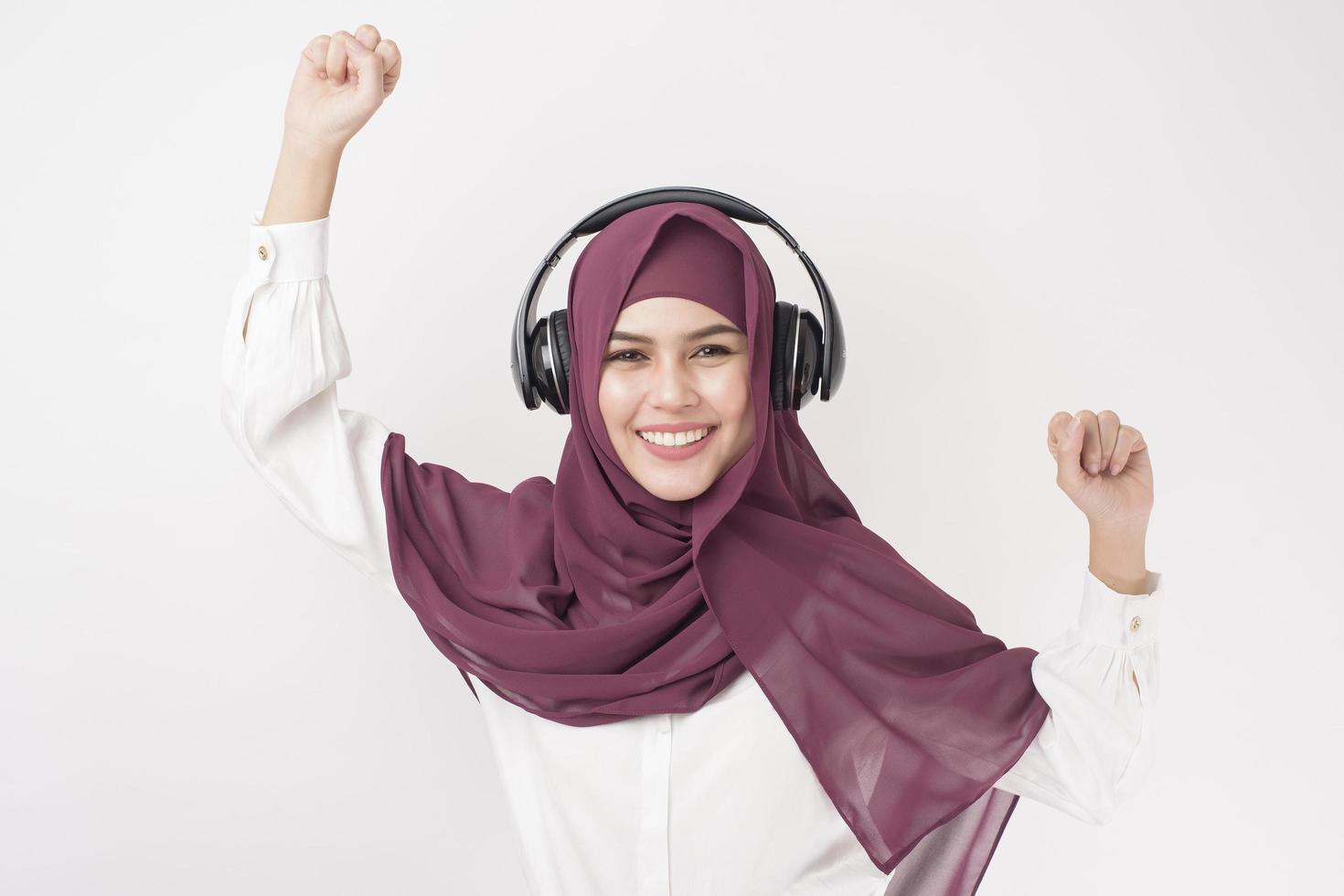el retrato de una mujer hermosa con hiyab es disfrutar escuchando música con fondo blanco foto
