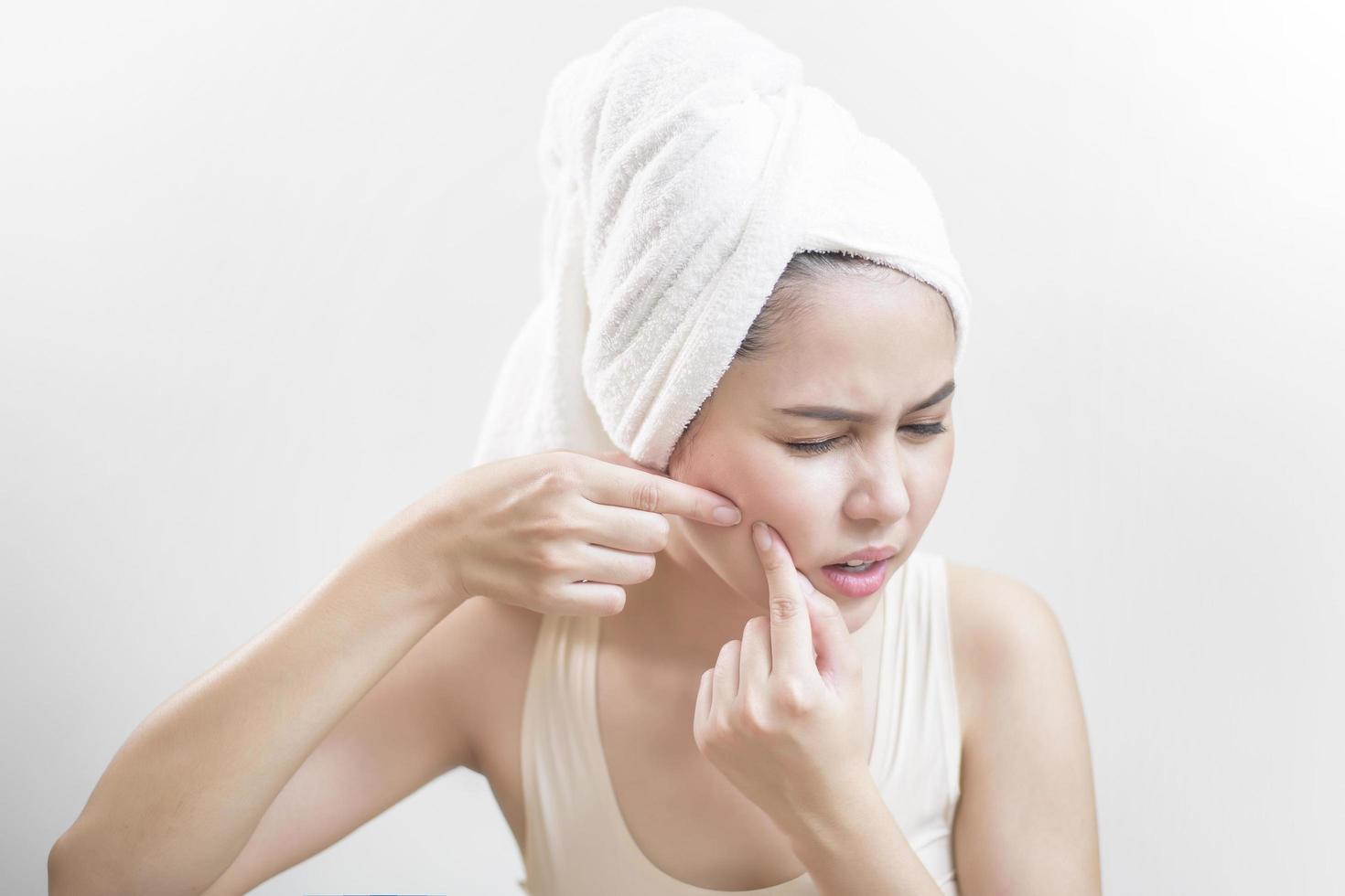 A woman is popping a pimple photo