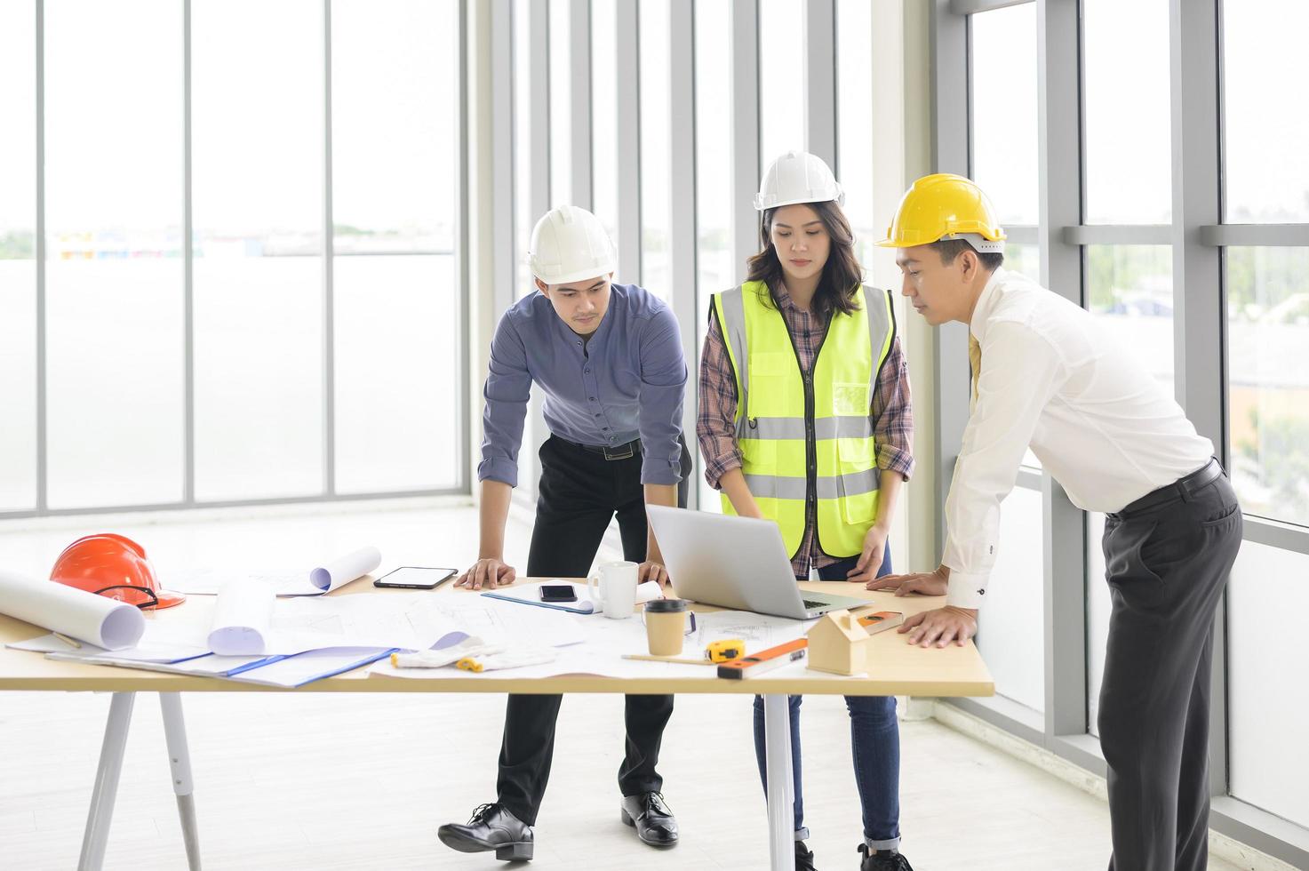 los ingenieros son planes de construcción analíticos con planos en la oficina foto