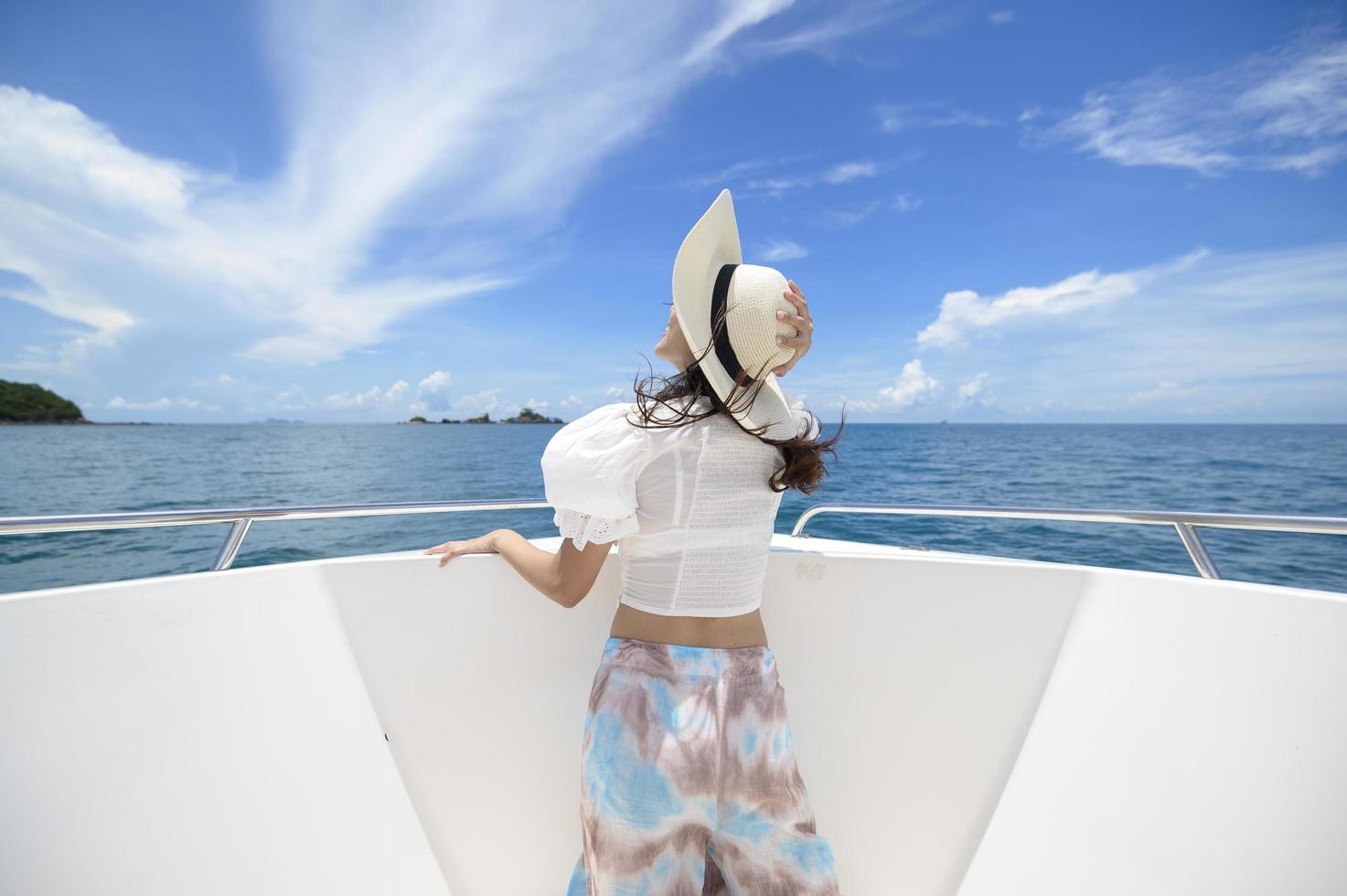 excited tourist enjoying and relaxing on speedboat with a beautiful view of ocean and mountain in backgound photo