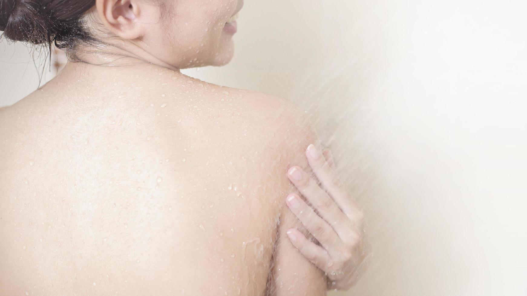 Happy  beautiful woman is taking a shower photo