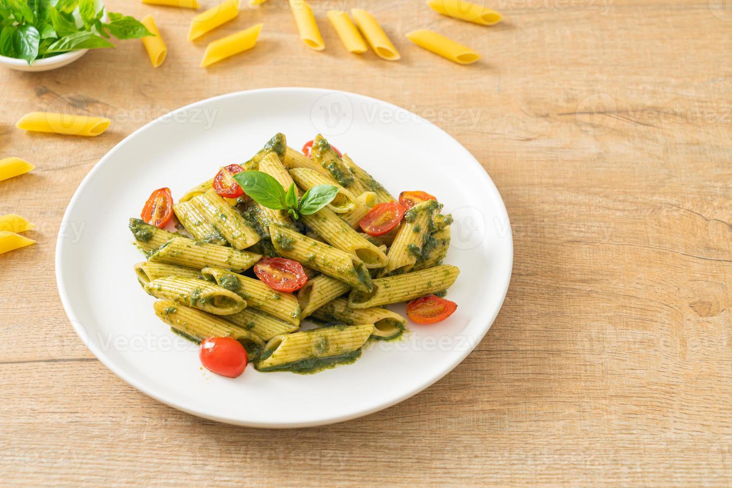 penne pasta with pesto sauce and tomatoes photo