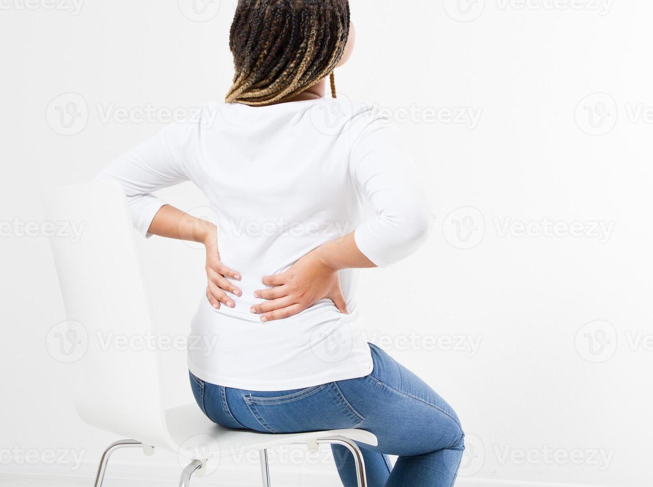 beautiful woman suffering from backache on chair - back view photo