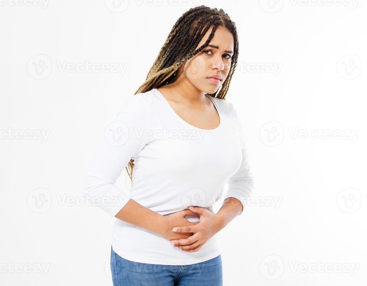 mujer afroamericana con dolor de estómago doloroso sobre fondo blanco.gastritis crónica. concepto de hinchazón del abdomen. foto