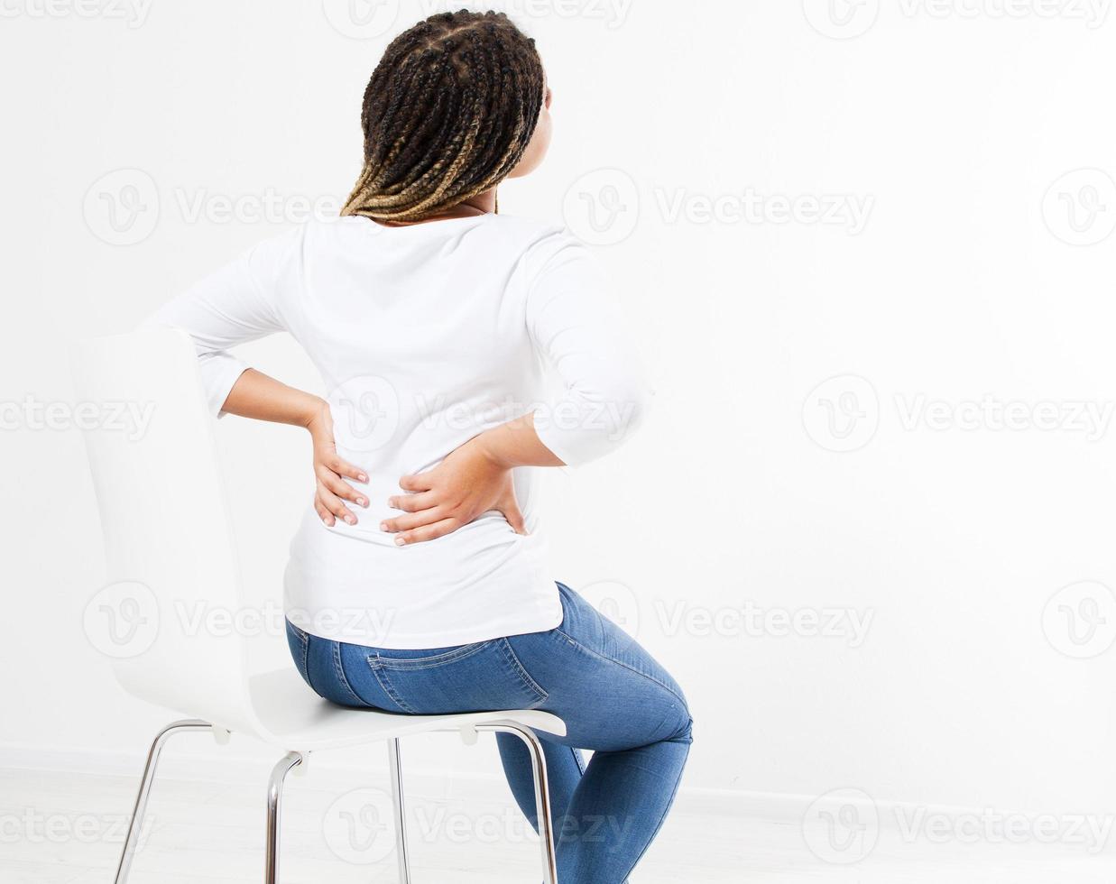 beautiful woman suffering from backache on chair - back view, female rheumatism copy space photo