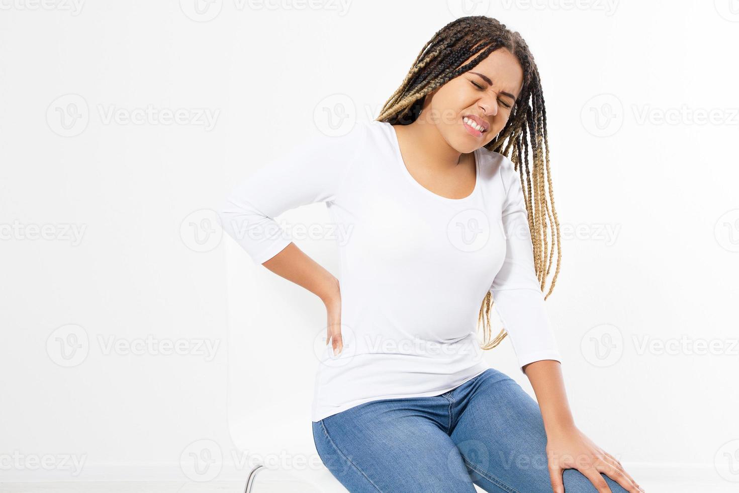 beautiful young woman suffering from backache on chair - front view photo